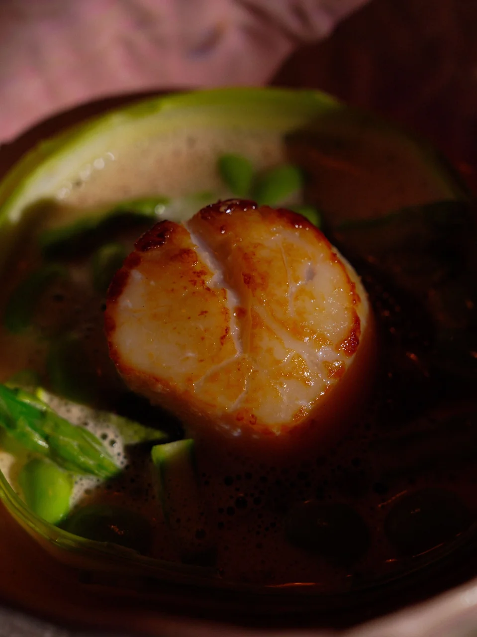 Plated seared king scallop with emerald asparagus and delicate emulsion