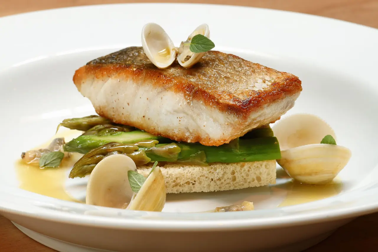 Gourmet French fish dish with fresh asparagus and delicate herb garnish