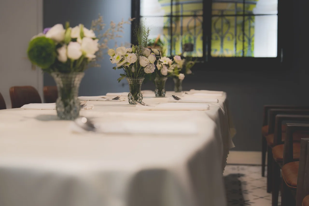 Elegantly arranged dining table with crisp linen, glassware and refined floral touch