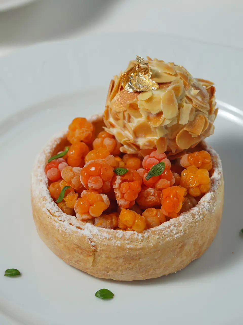 Artisan French dessert tart with almond caramel swirl and gold leaf garnish