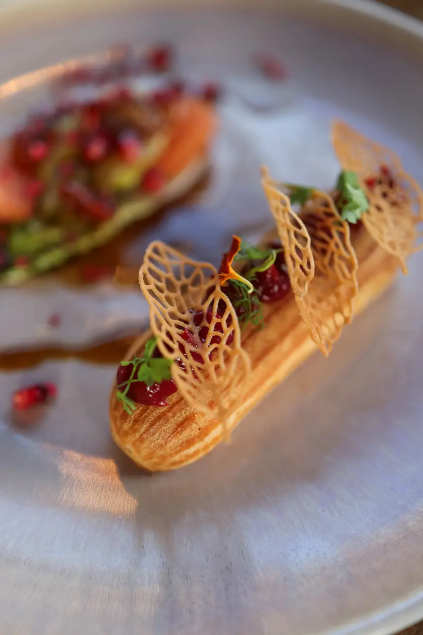 Delicate French choux éclair finished with fresh pomegranate pearls