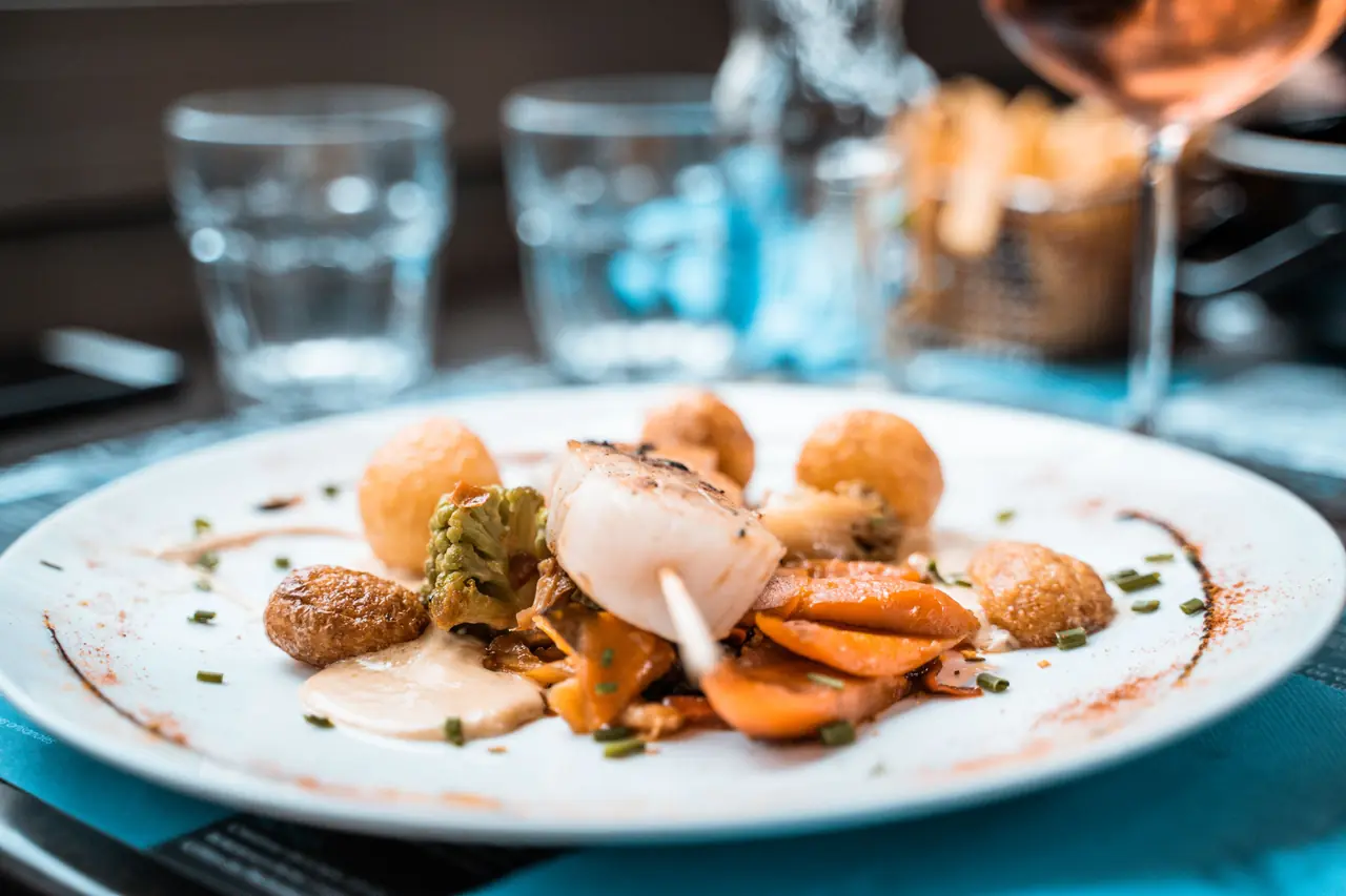 Carefully plated French scallop dish with vegetable accompaniment